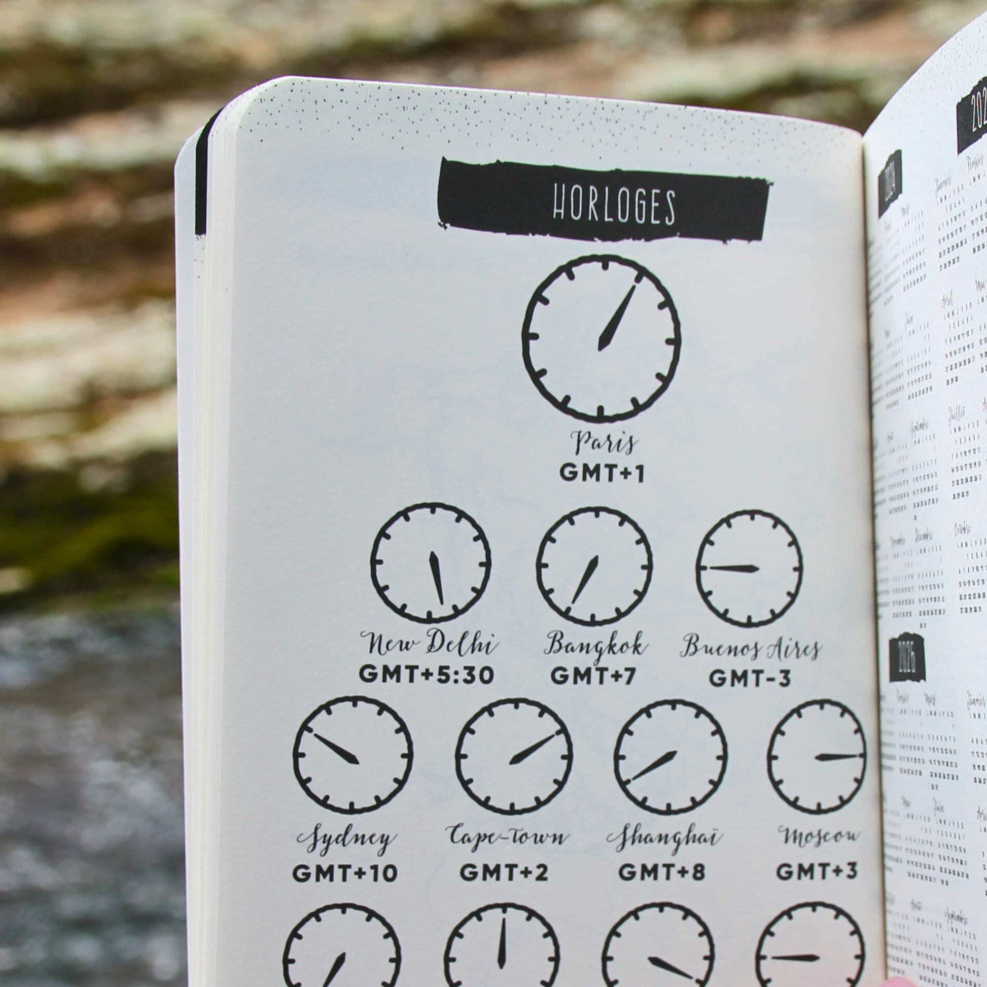 Carnet de voyage ouvert sur la page des fuseaux horaires, utile pour suivre les décalages entre les pays visités.