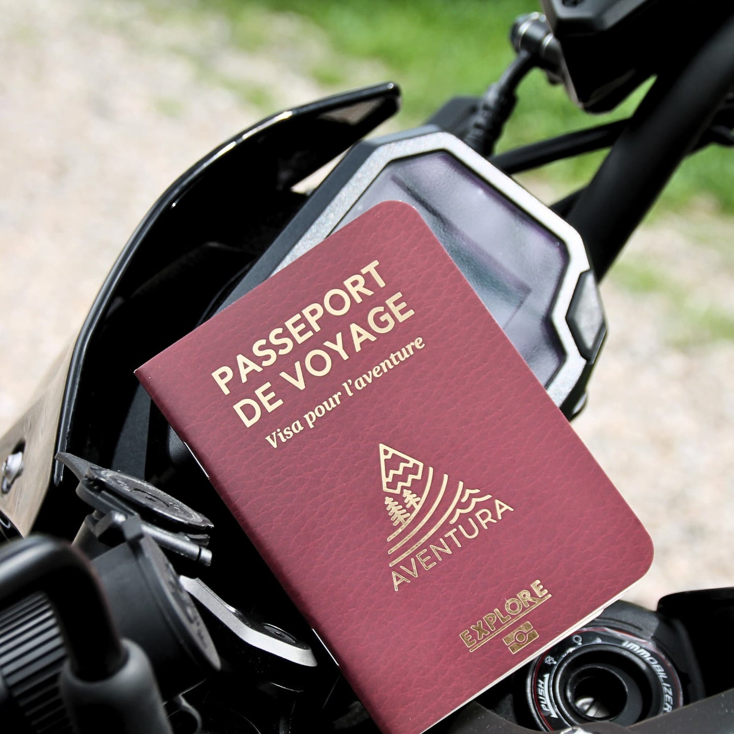 Passeport du voyageur fermé, posé dans une mise en scène évoquant l’aventure et l’exploration à moto.