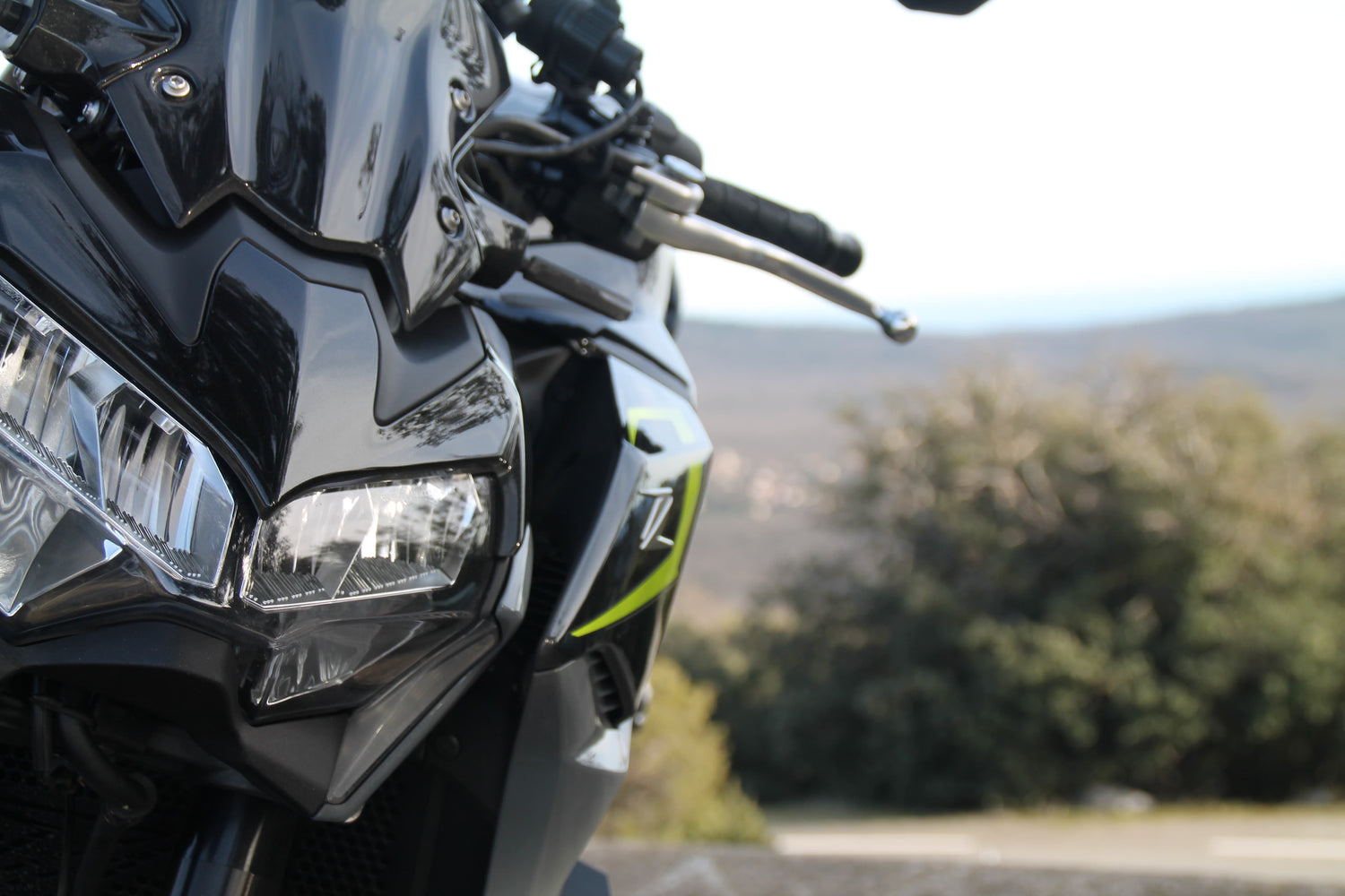 Photo d'une kawasaki Z900 de 2024 vue de face, zoom sur le phare avant.