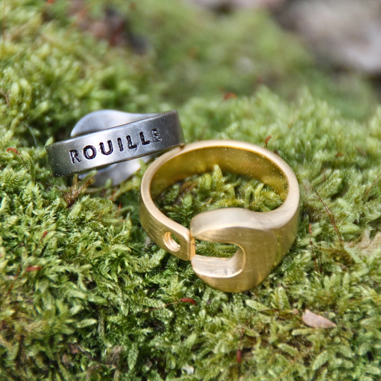 Bagues en acier inoxydable doré et argenté de la marque italienne Rouille. Le design en clé plate est original et fashion. Le dos de la bague est gravé de Rouille