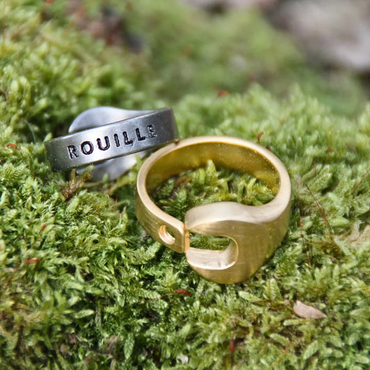 Bagues en acier inoxydable doré et argenté de la marque italienne Rouille. Le design en clé plate est original et fashion. Le dos de la bague est gravé de Rouille