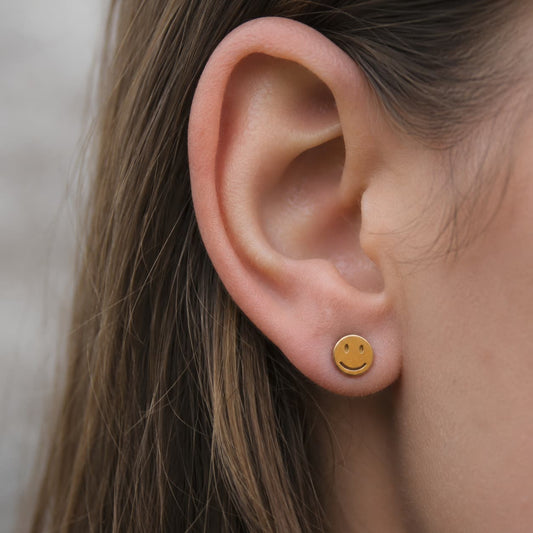 Boucles d'oreilles smiley acier inoxydable doré porté par une motarde