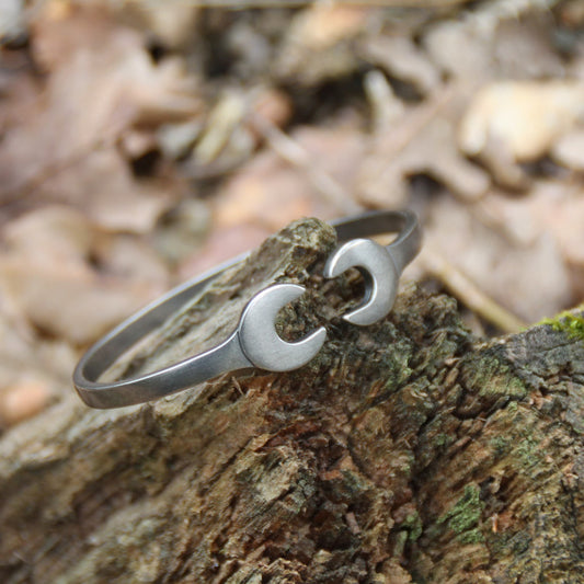 Bracelet jonc en acier inoxydable argenté en forme de double clé plate, signé Rouille – Un bijou au style industriel et élégant.