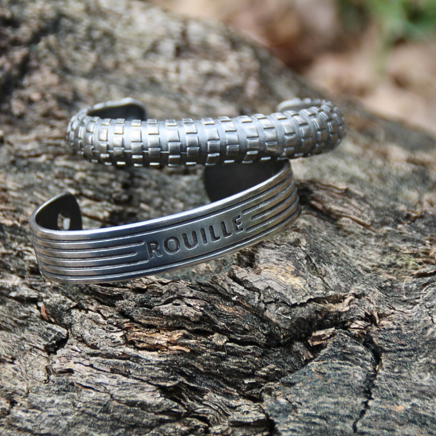 Stylé et moderne : 2 bracelets joncs en acier inoxydable argenté, l’un représentant un pneu, l’autre un moteur, créés par la marque italienne Rouille.