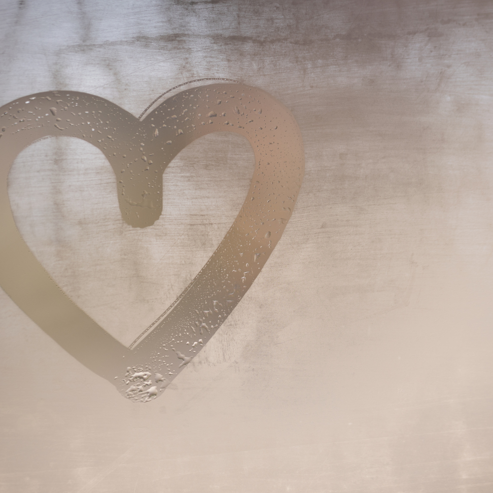 Illustration d'un cœur en buée sur une fenêtre.