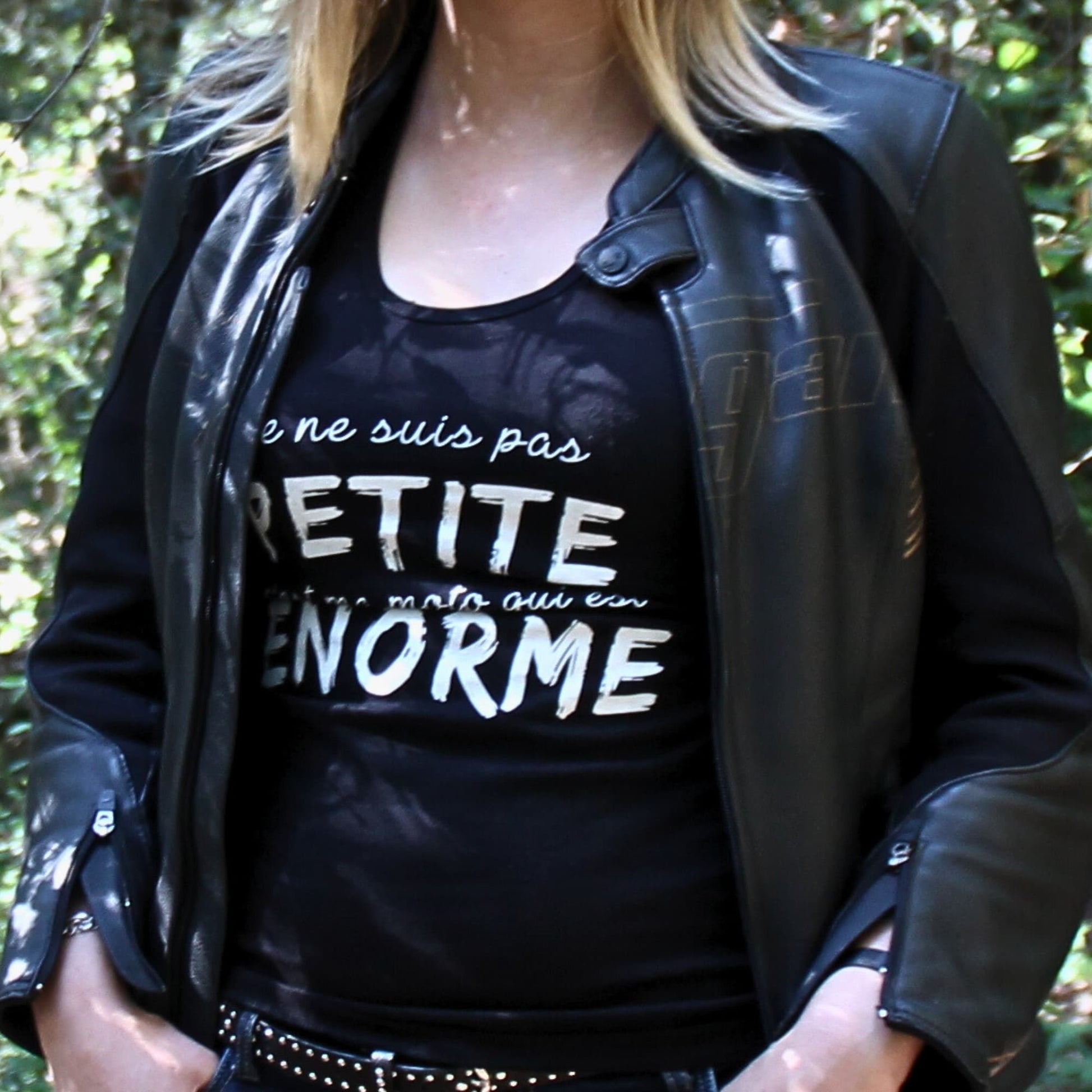 Débardeur femme en coton avec inscription "Je ne suis pas petite, c’est ma moto qui est énorme", porté sous une veste en cuir.