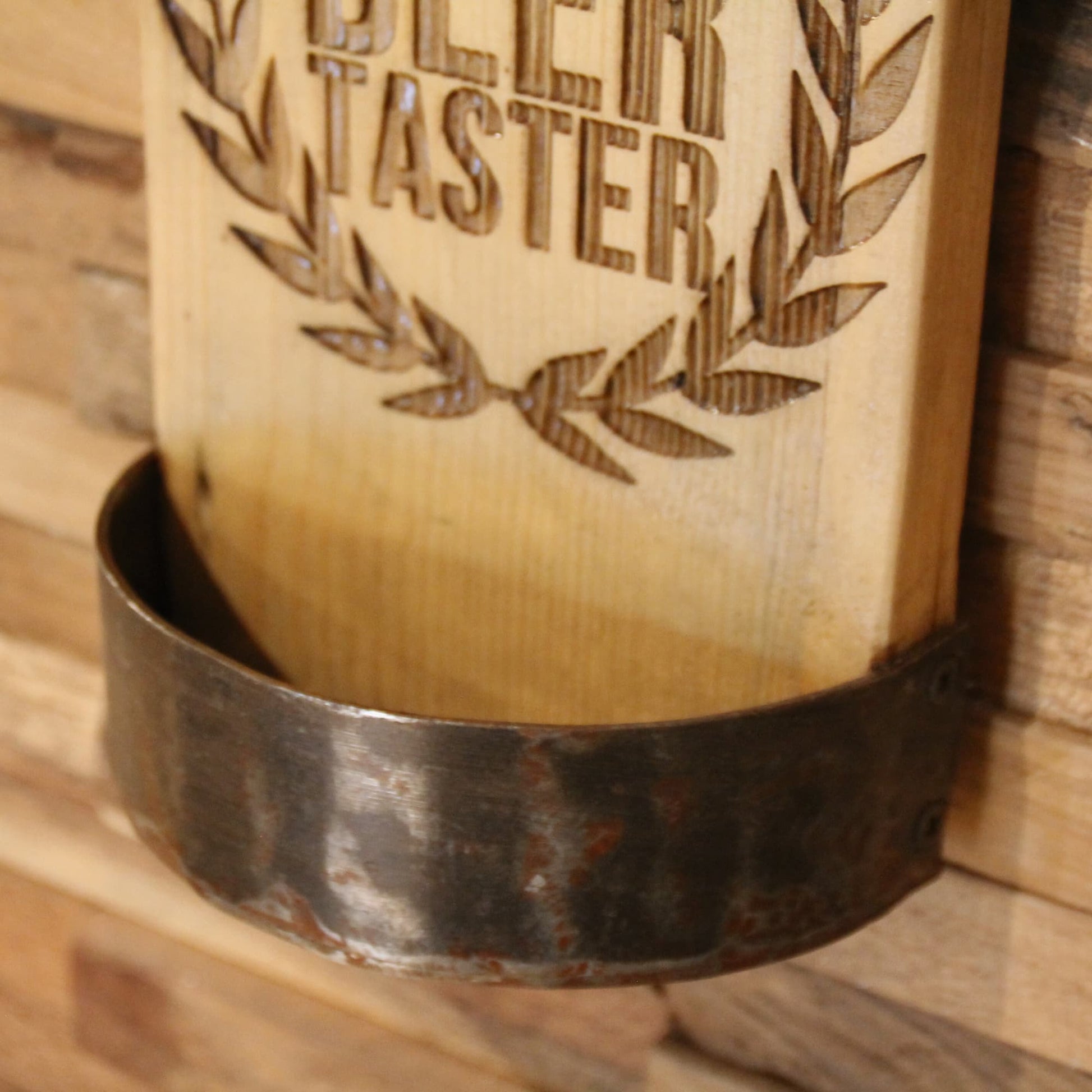 Zoom sur le bac de récupération de capsules arrondi du décapsuleur en bois fait à la main et gravé "Professional Beer Tester".