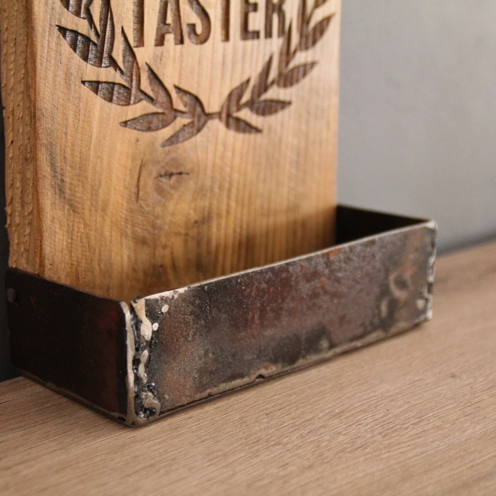 Zoom sur le bac de récupération de capsules en forme rectangulaire du décapsuleur en bois fait à la main et gravé "Professional Beer Tester".