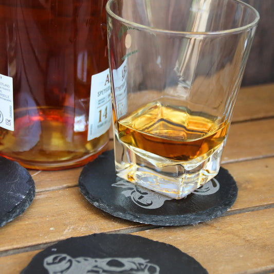 Dessous de verre en ardoise présenté avec un verre rempli.