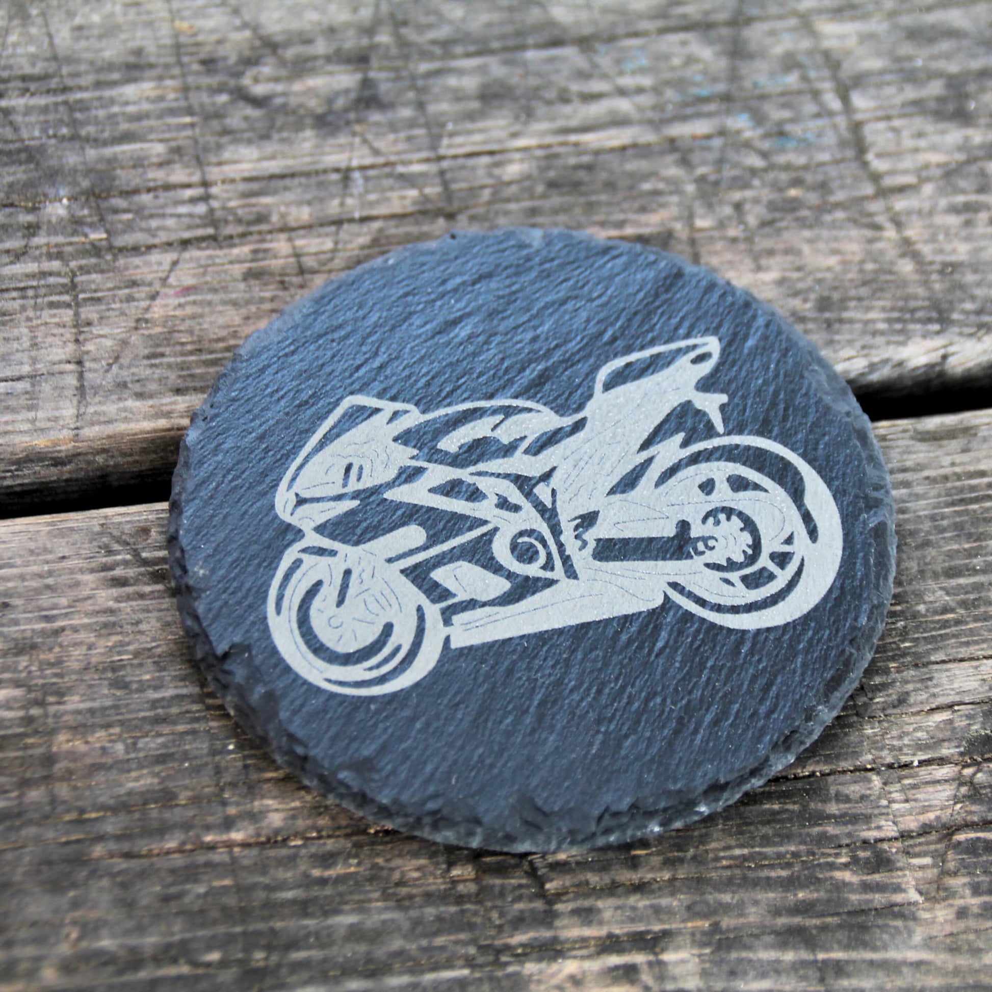 Dessous de verre rond en ardoise naturelle gravé d'une moto style sportive.