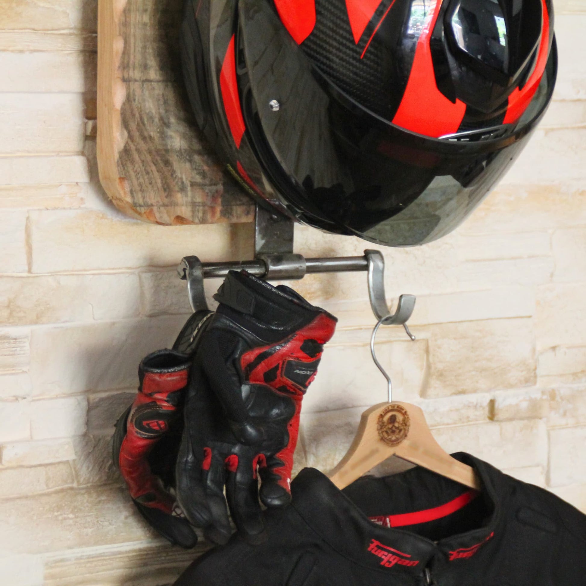 Support de casque moto mis en situation avec casque, gants et veste sur cintre.