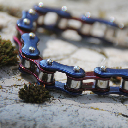 Zoom sur le bracelet style chaine de moto en acier inoxydable couleur bleu et pourpre.