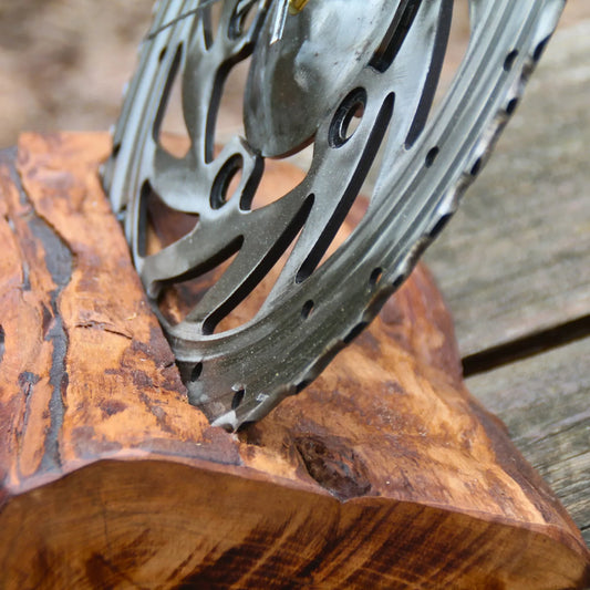 Details de l'horloge mécanique en bois et disque de frein moto.