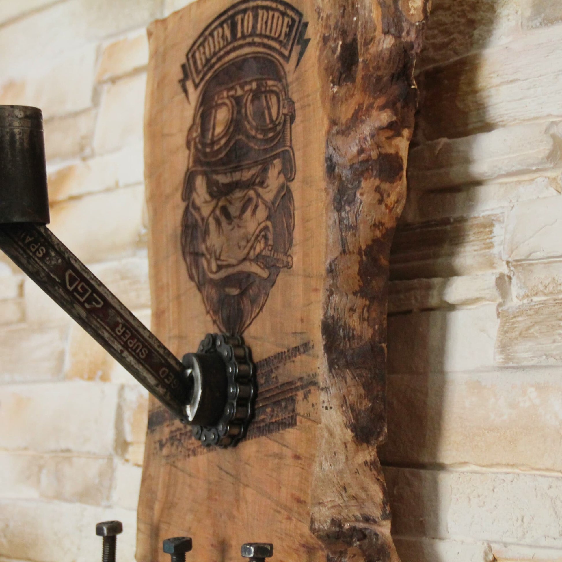 Zoom sur la gravur et les pièces mécaniques composant le Support de casque moto fait main en bois d'arbre fruitier