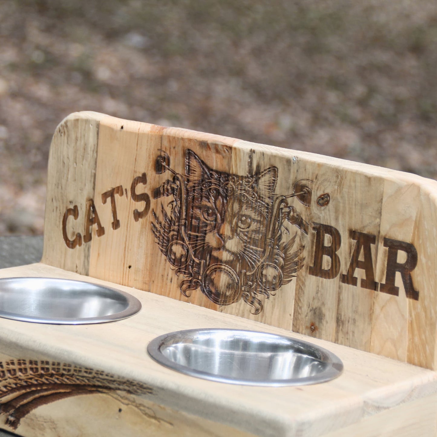Zoom sur la double gamelle pour chat en bois gravé d'un chat motard au guidon de sa moto