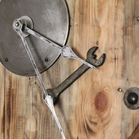Zoom sur les aiguilles et clé plate de l'horloge en bois.