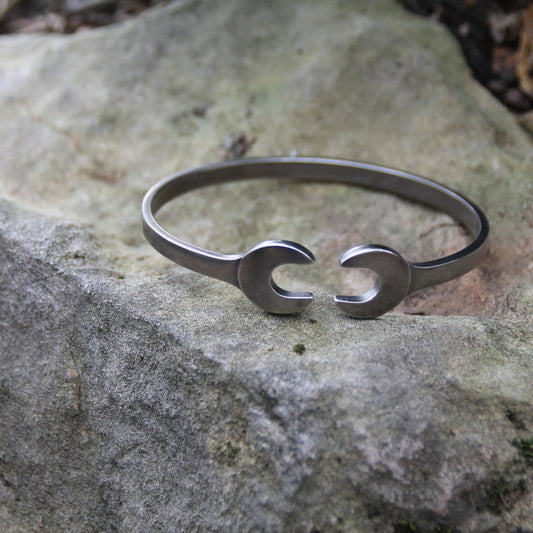 Zoom sur le bracelet jonc en acier inoxydable argenté, design double clé plate de la marque Rouille, fabriqué en Italie.