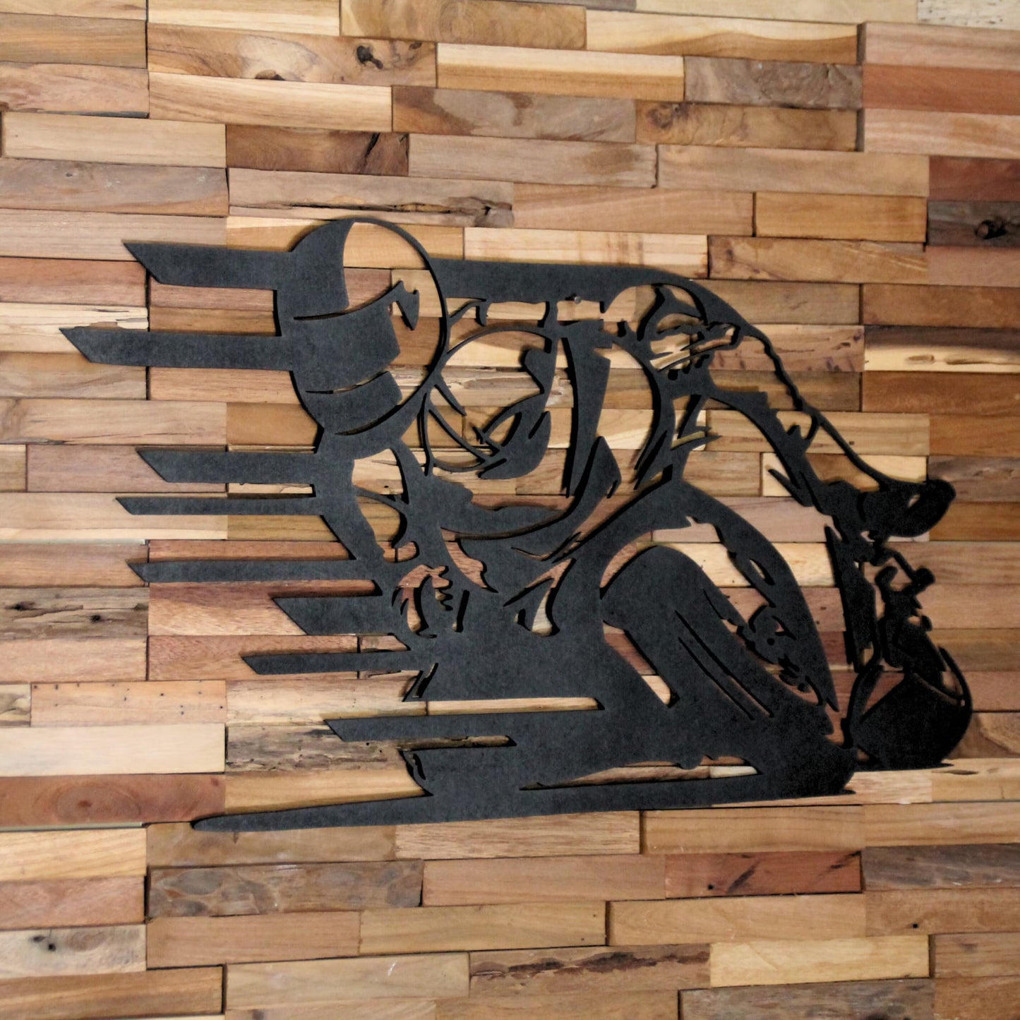 Tableau découpé au laser en bois contreplaqué, montrant un pilote penché sur sa moto.