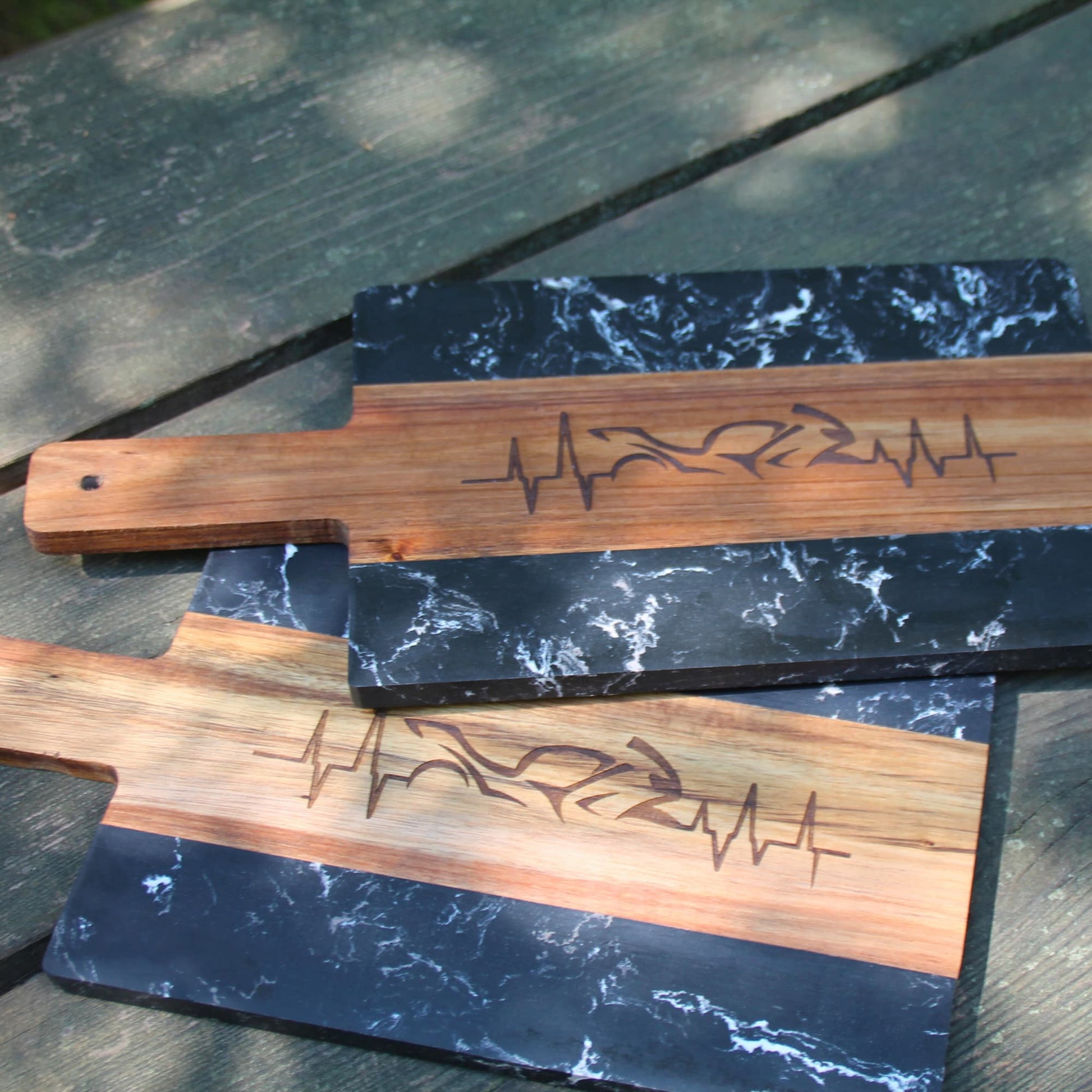 Duo de planches apéritives en bois naturel et mabre gravées d'une ligne de battements de coeur et d'une moto.