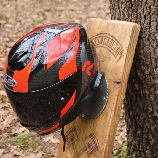 Support casque moto mural "Born to Ride" en bois traité sombre – un casque intégral posé sur repose-casque boule pétanque recyclée