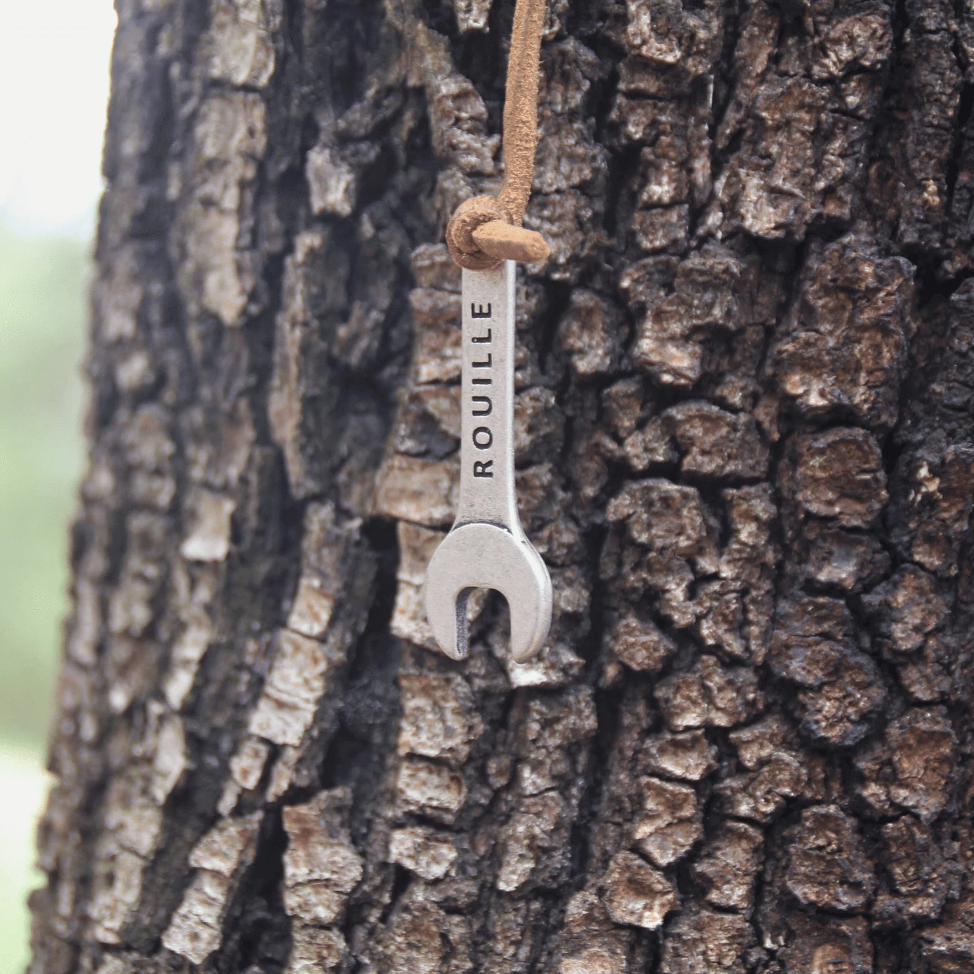 Zoom sur le porte-clés clé à molette gravé, effet rouillé, avec lanière en cuir – Idéal pour un look industriel.