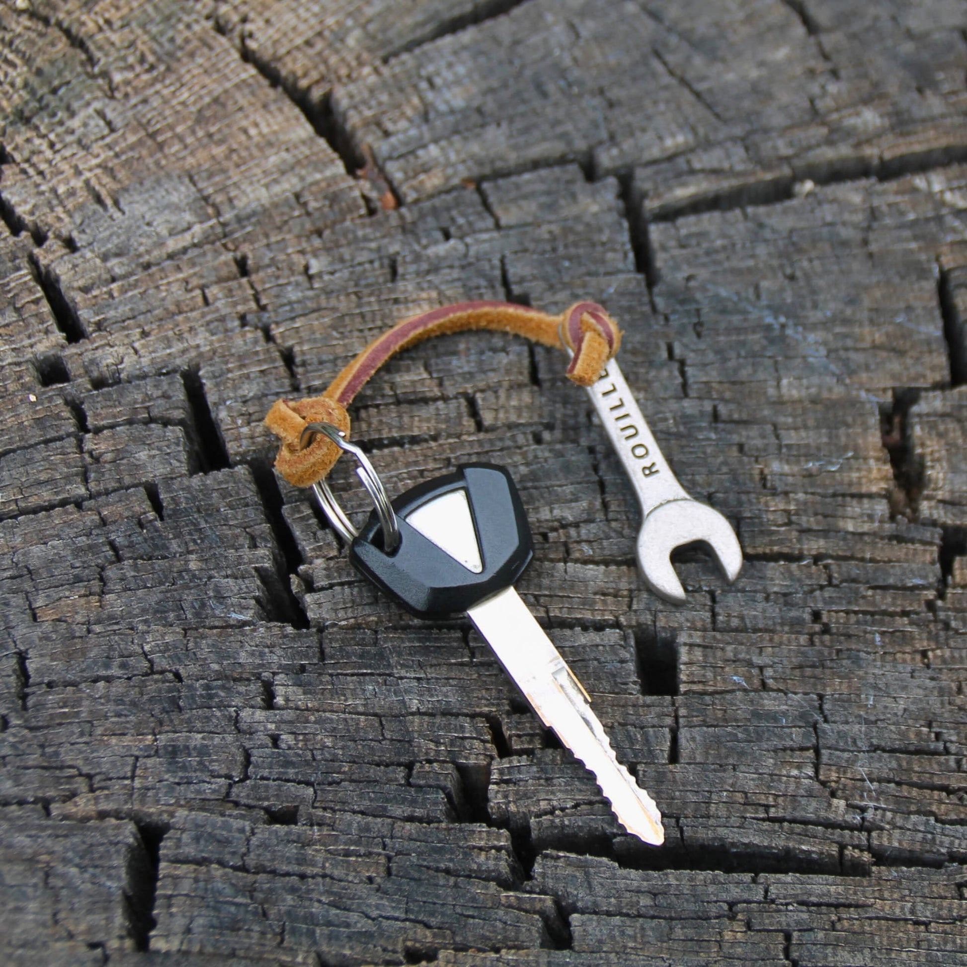 Porte clé original en forme de clé plate avec cordon en cuir.