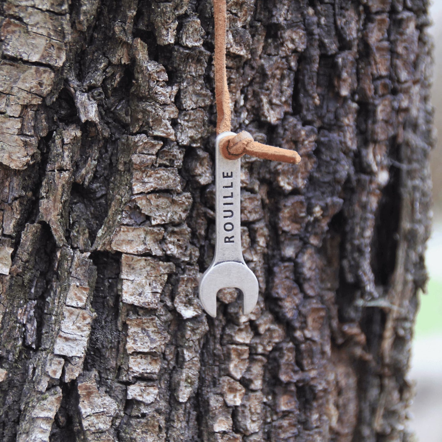 Détail du porte-clés clé à molette en métal gravé, aspect rustique et cuir – Parfait pour un cadeau original.