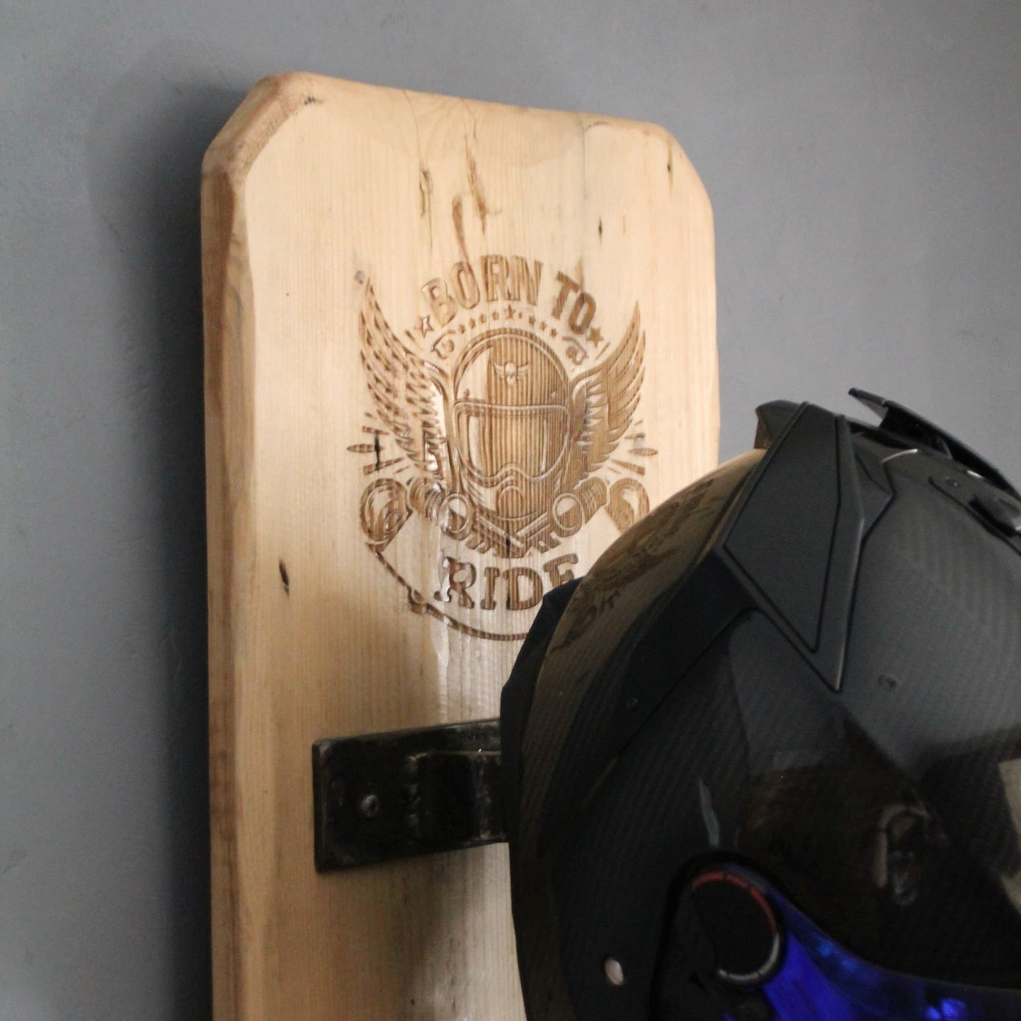 Zoom sur le haut du support de casque moto artisanal en bois avec casque posé, alliant esthétique et fonctionnalité.