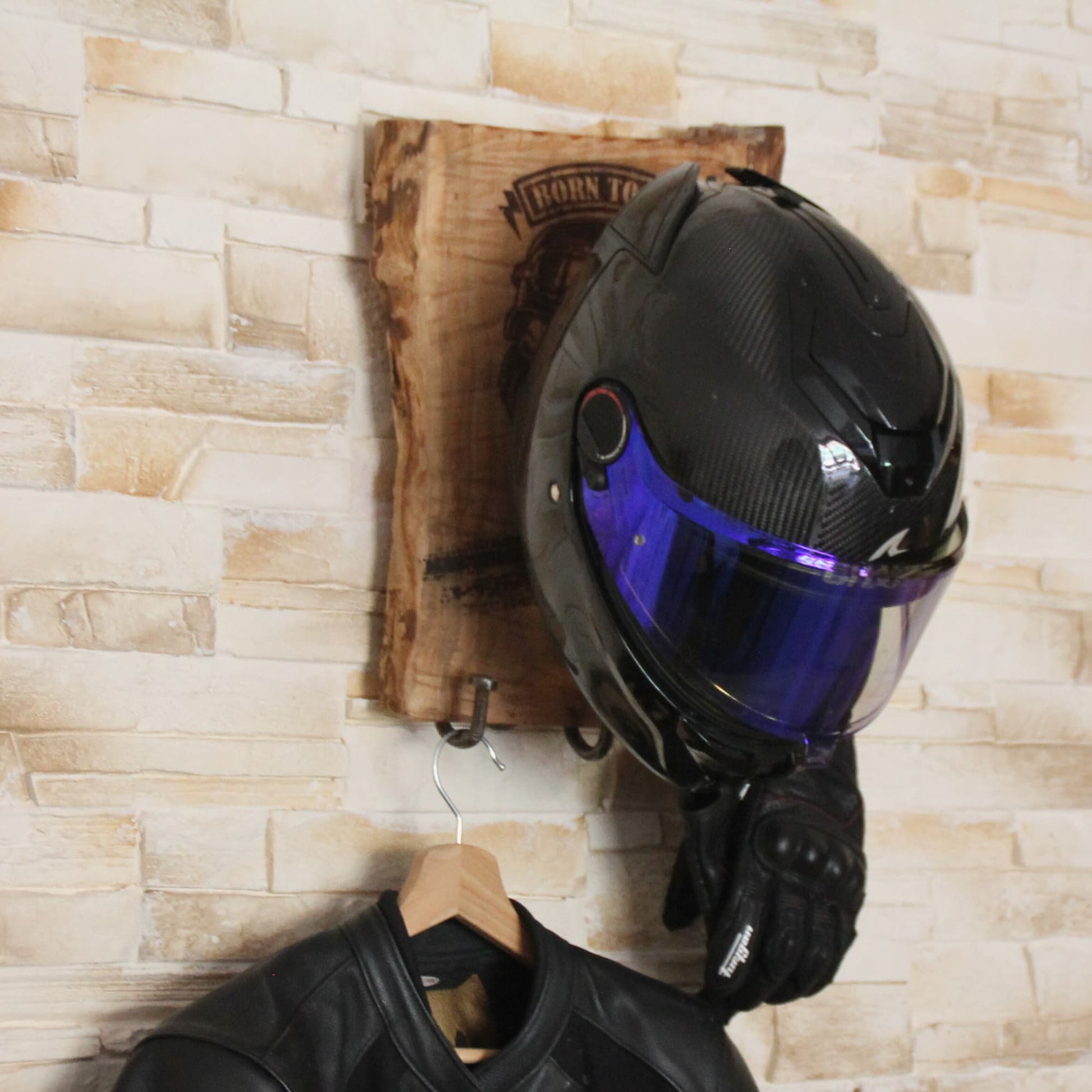 Support de casque moto fait main en situation avec casque gants et veste sur cintre.