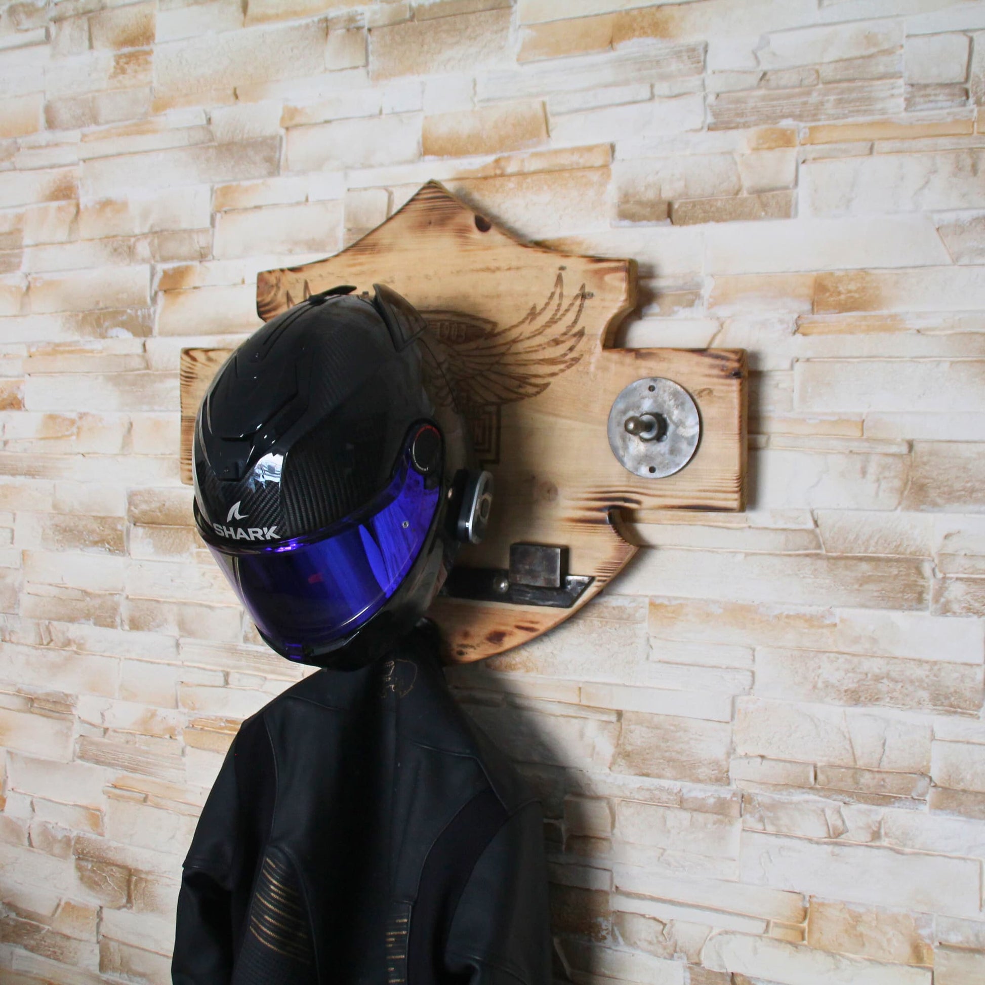 Support de casque en bois mis en situation avec un casque et une veste posés dessus.