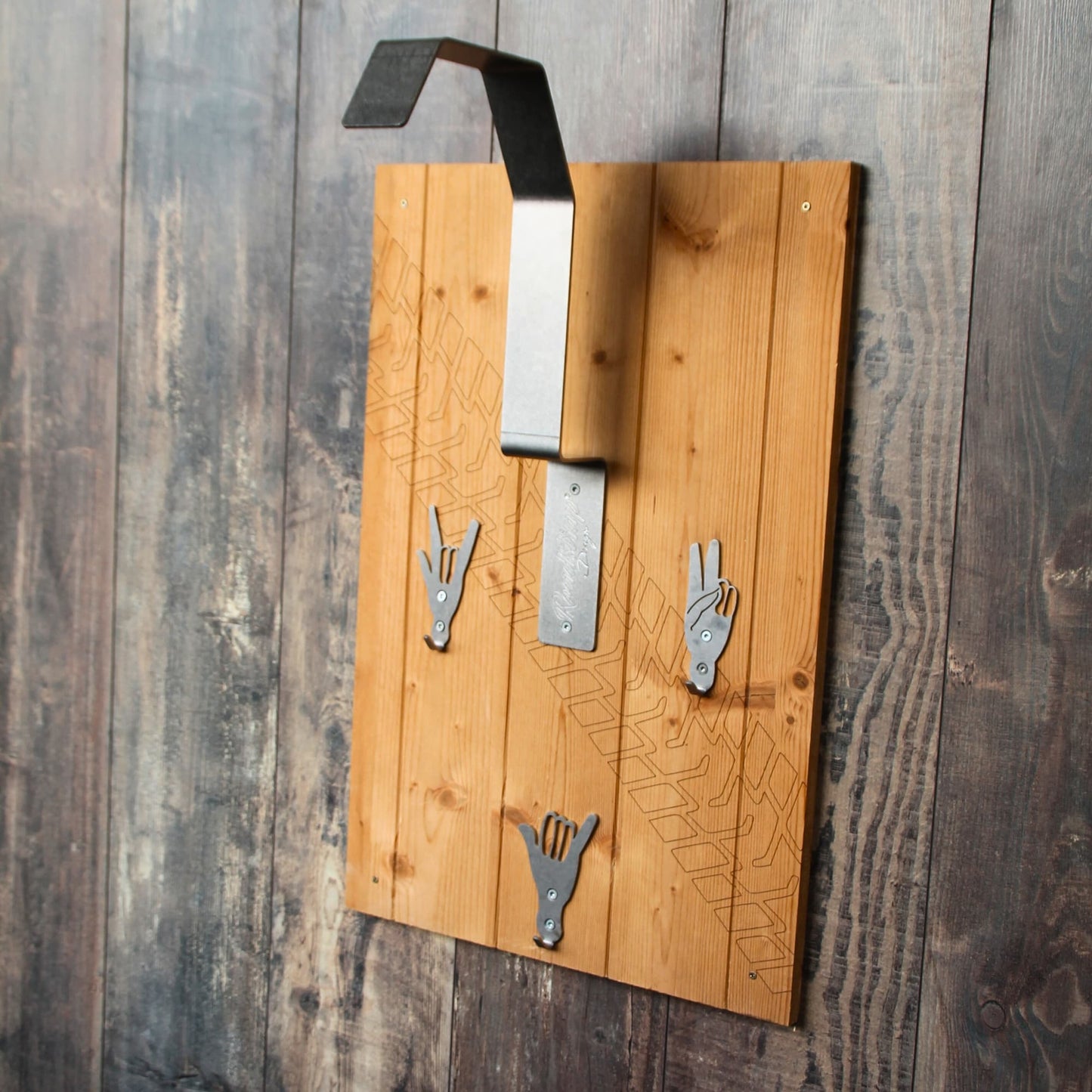 Support de casque moto Roadstrap , panneau en bois naturel gravé d'une trace de pneu. Il est composé de support pour poser son casque de moto, et de crochets V, fun et rock. Fixations incluses