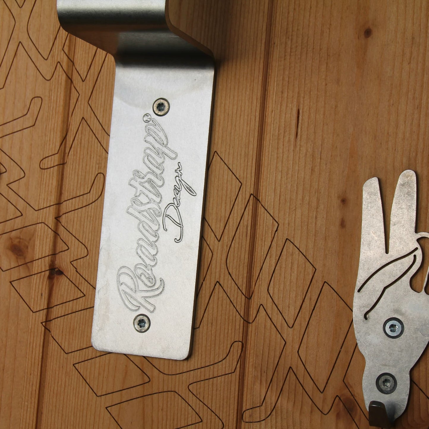 Détail de la gravure pneu sur le panneau bois du support Roadstrap.