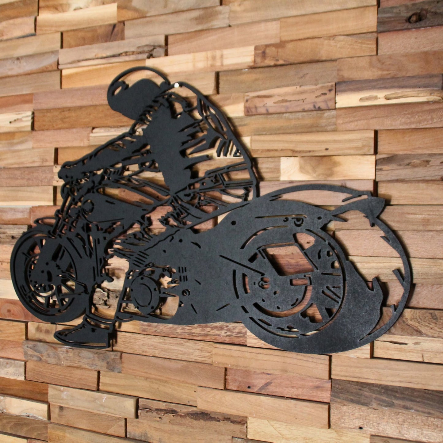 Tableau mural en bois représentant un biker sur sa moto, accroché sur un mur en bois – vue intérieure.