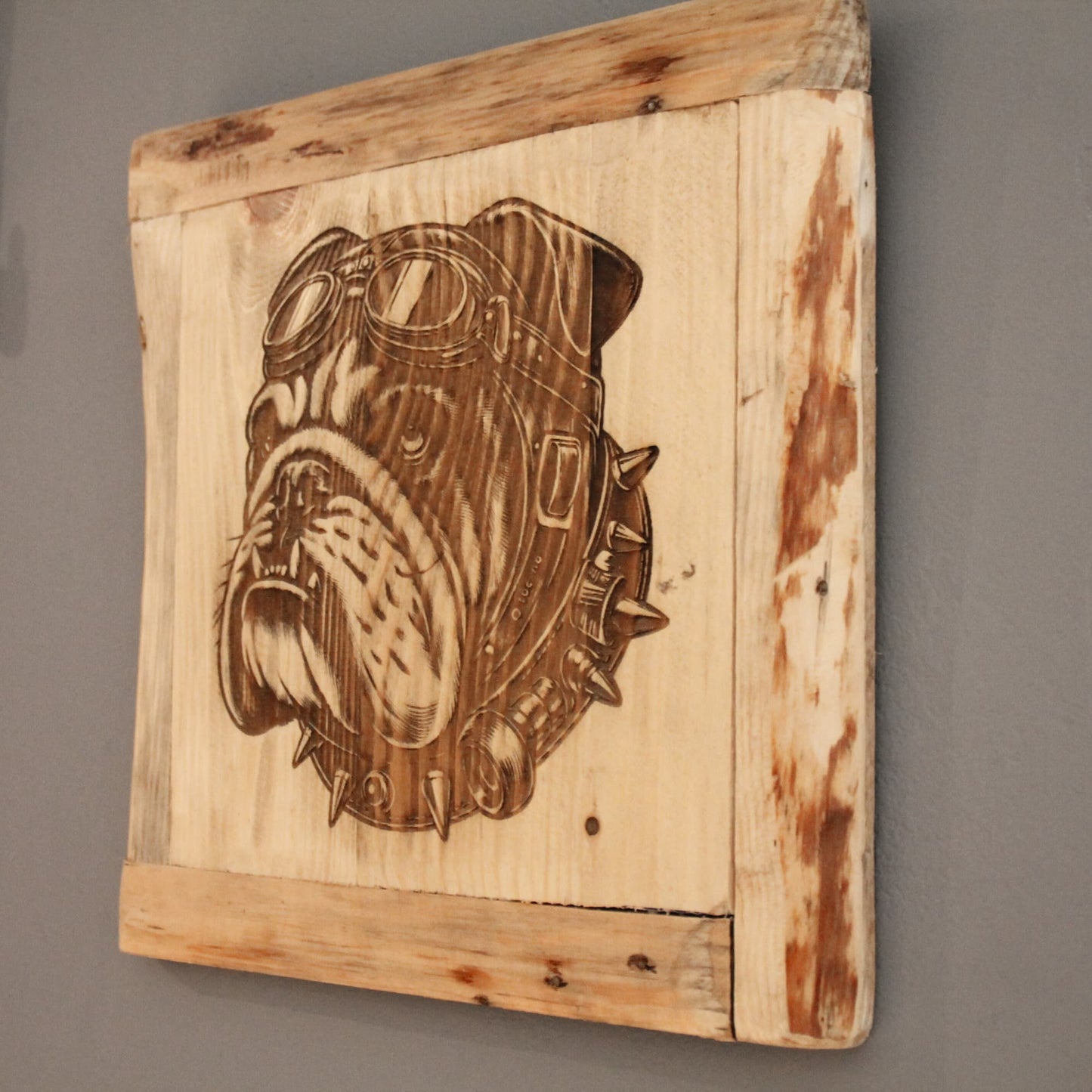 Détail sur le tableau en bois recyclé gravé d'un bulldog motard avec casque de moto, lunettes et collier.