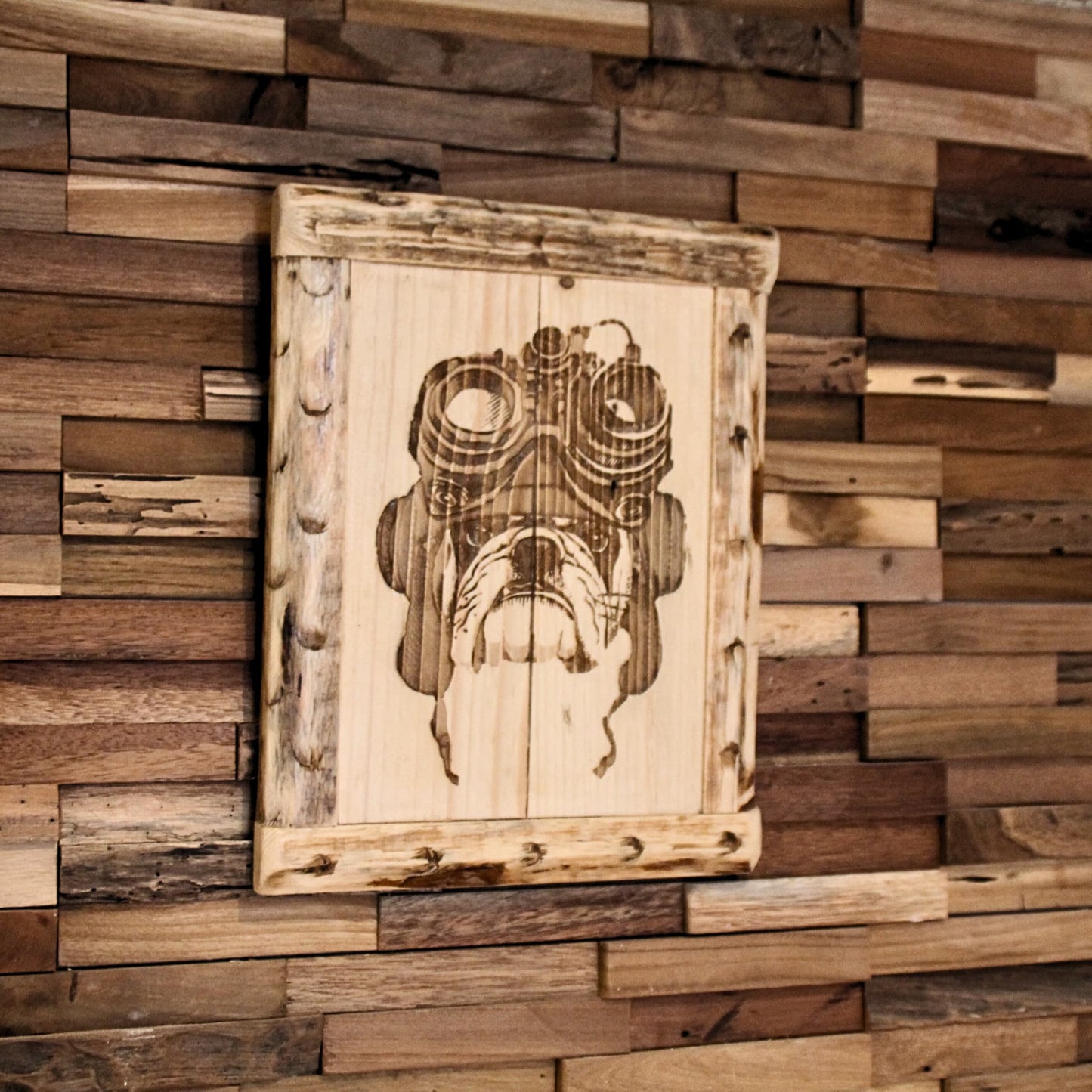 Détail d’un tableau en bois gravé montrant un bulldog motard avec son casque et ses lunettes – Ambiance biker garantie.