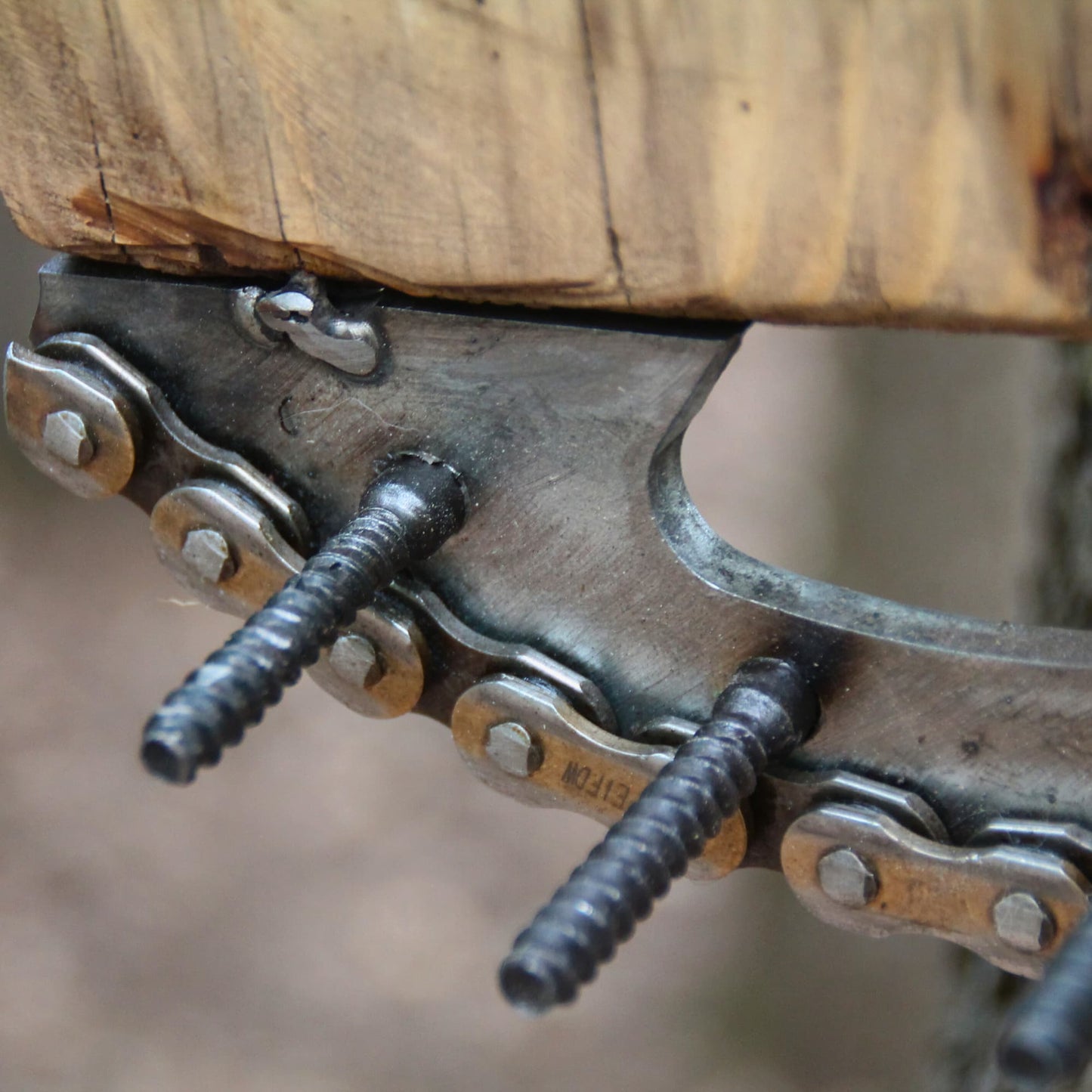 Zoom sur les pièces mécaniques recyclées formant le tableau mural en bois et porte clés