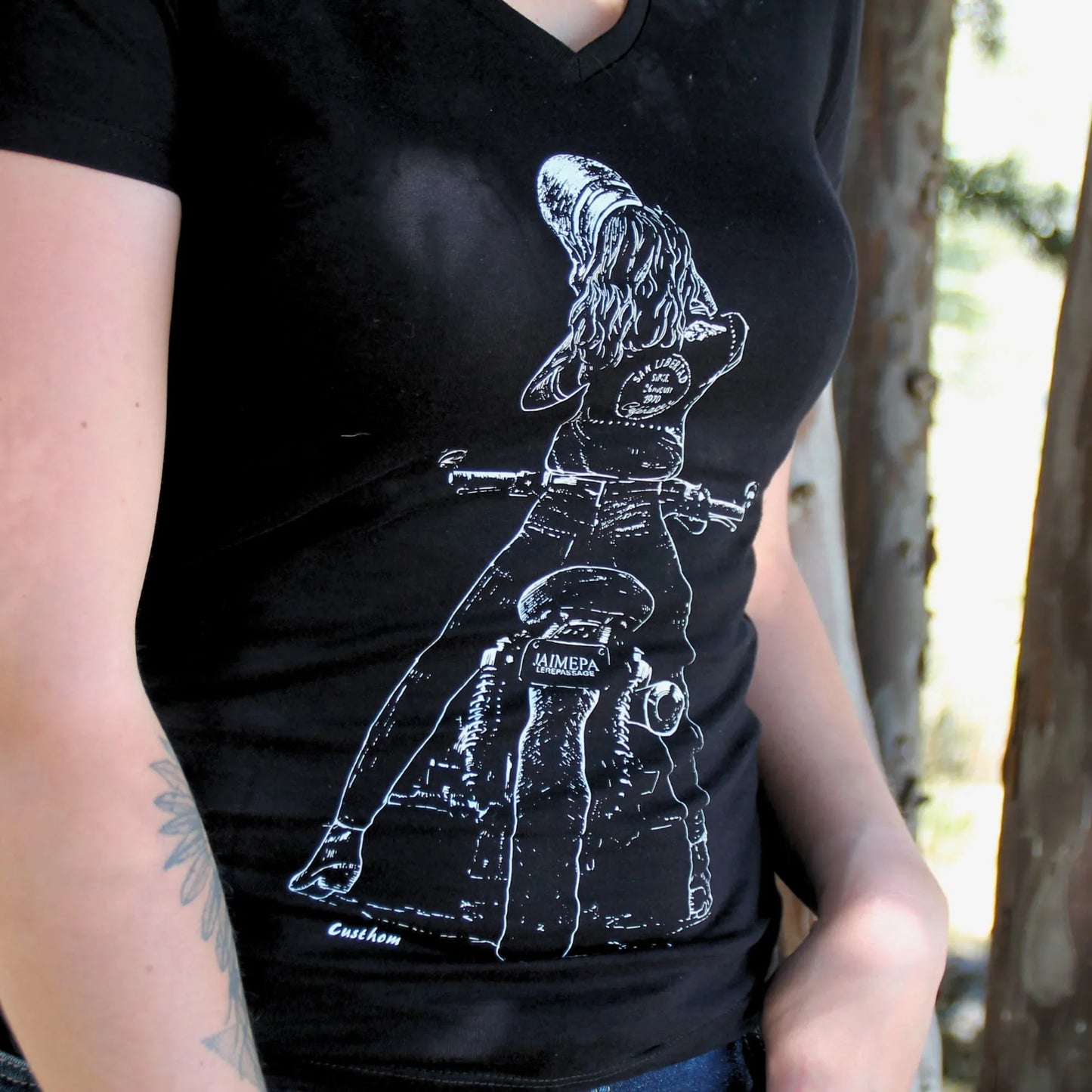 T-shirt féminin en coton noir avec une illustration élégante d’une motarde en pleine action, retirant son casque. Un design parfait pour les amoureuses de moto.