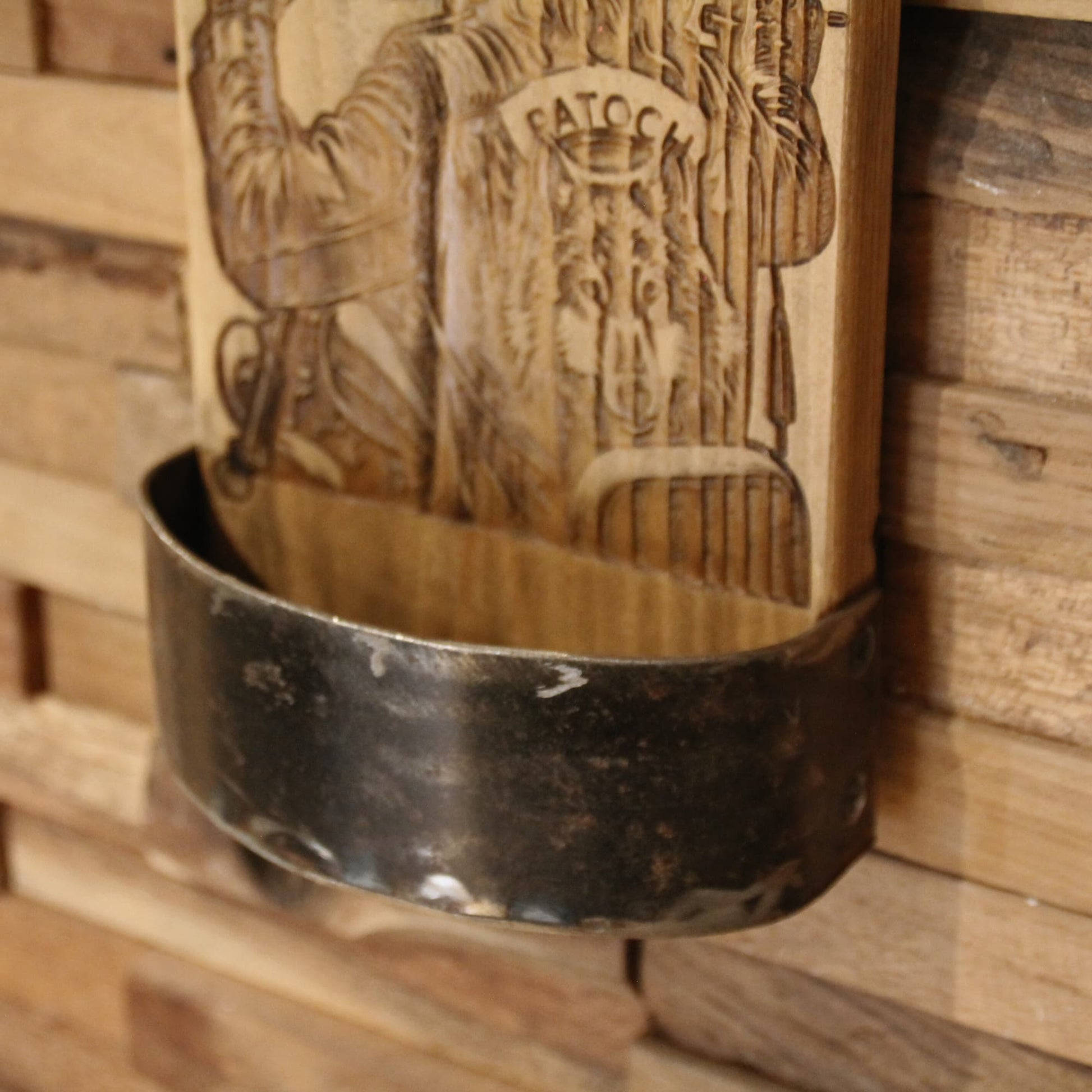 Zoom sur le bac de récupération de capsules du décapsuleur mural artisanal en bois et métal recyclé. Gravure biker Patoch