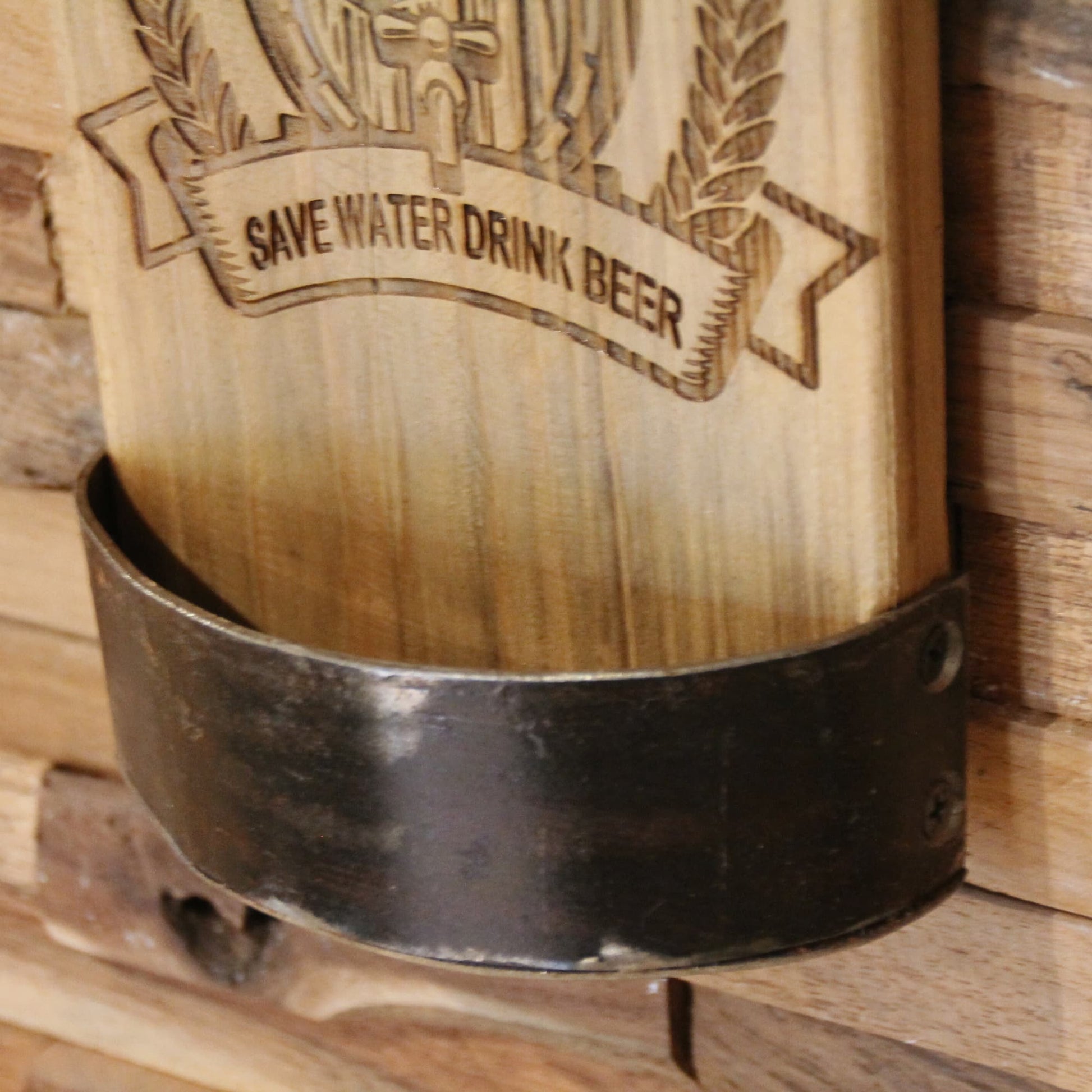 Zoom sur le bac de récupération de capsules du Décapsuleur mural artisanal en bois recyclé et métal. Gravure "Save water drink beer"