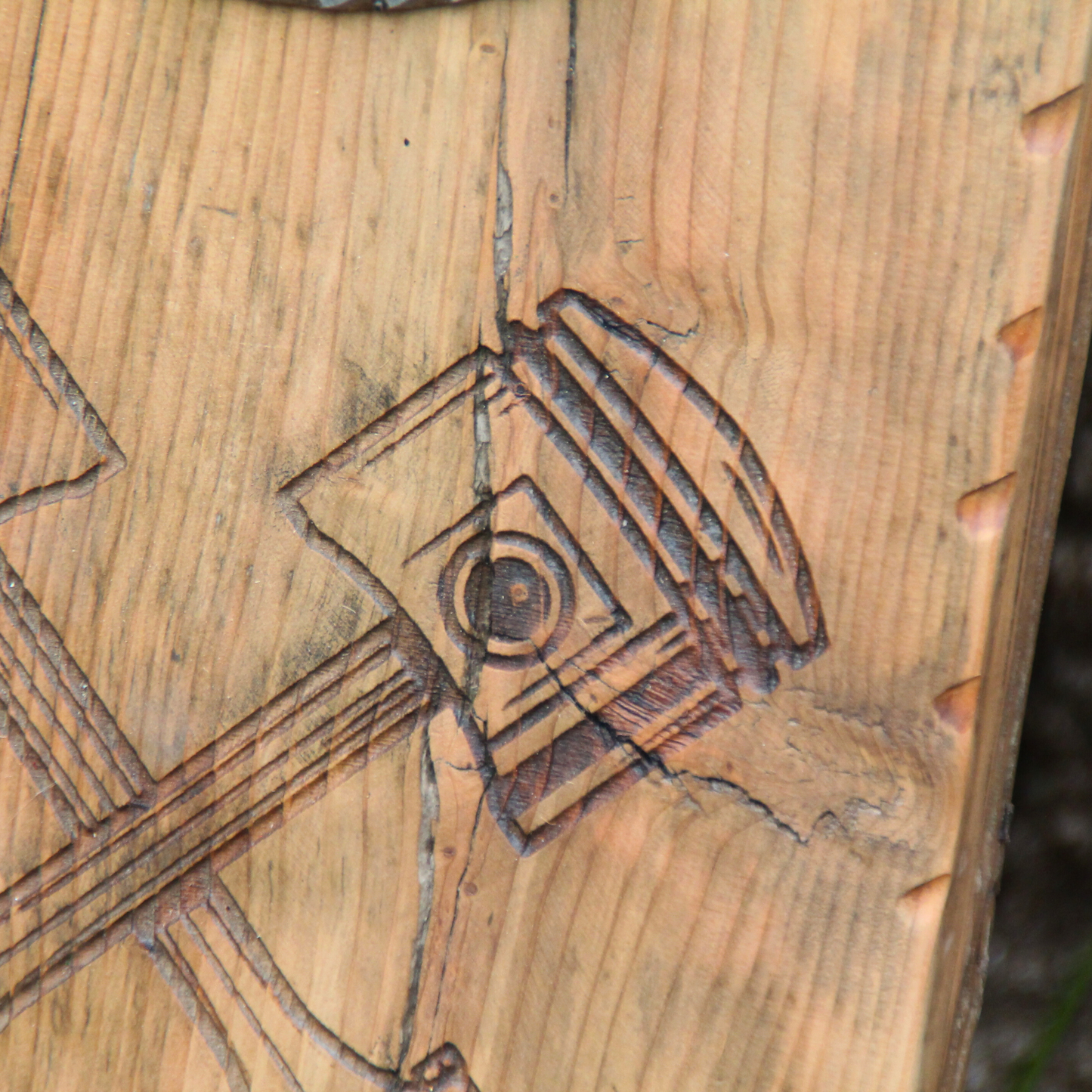 Détail fissure naturelle du bois au niveau de la gravure pistons sur porte casque moto mural "Born to Ride" – patine authentique sans impact solidité