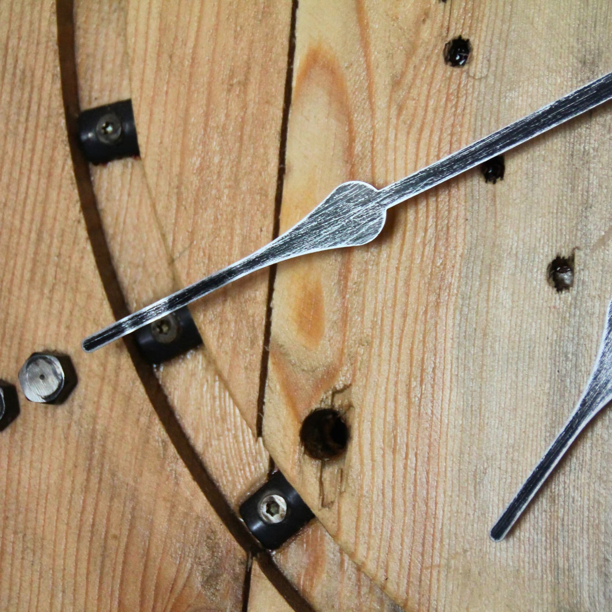 Zoom sur l'aigtuille de l'horloge en bois et métal recyclé. Piece unique