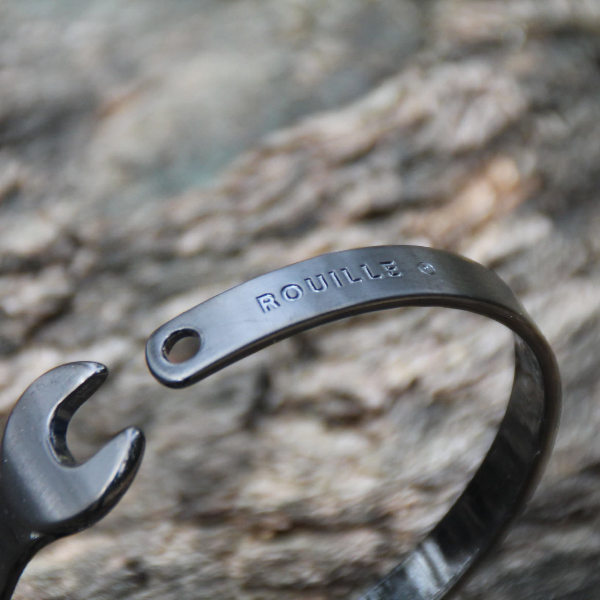 Zoom sur le bracelet jonc clé à molette en acier inoxydable noir Rouille – Détail de la finition gravée lisse et soignée.