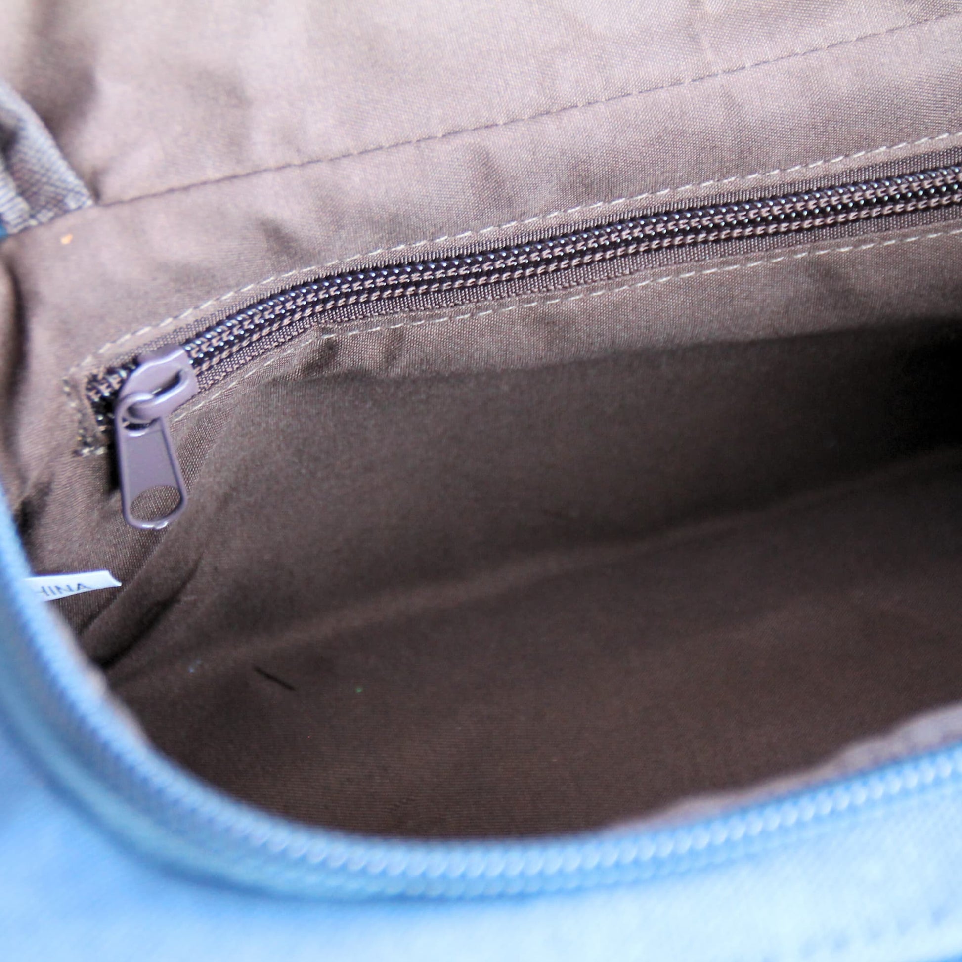 Zoom sur la poche intérieure de la trousse de toilette en tissu.