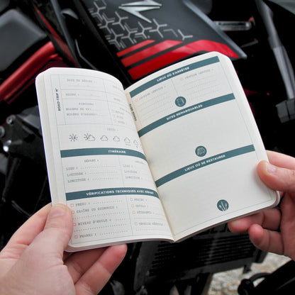 Carnet Road Trip moto ouvert sur une page "Road Trip" sur laquelle vous pouvez indiquer votre trajet du jour et souvenirs de voyage