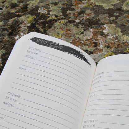 Carnet de voyage ouvert sur la page "Recettes du monde", permettant de noter des spécialités culinaires découvertes en voyage.