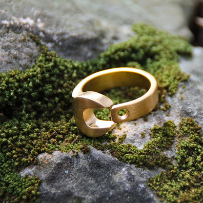 Bague en acier inoxydable doré de la marque italienne Rouille. Le design en clé plate en fait un accessoire audacieux 