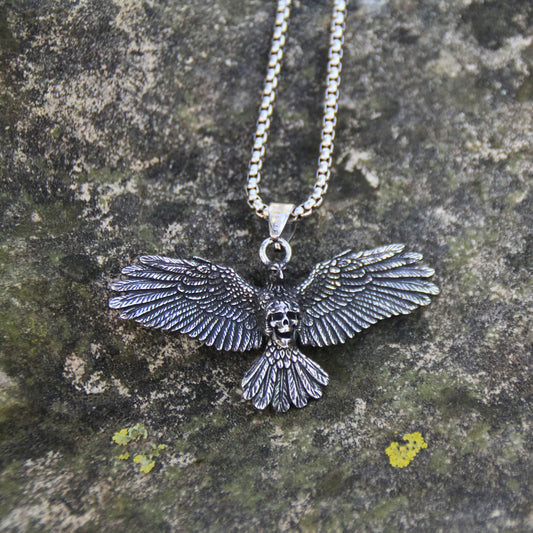Collier acier inoxydable pendentif oiseau aux ailes ouvertes tenant un crâne