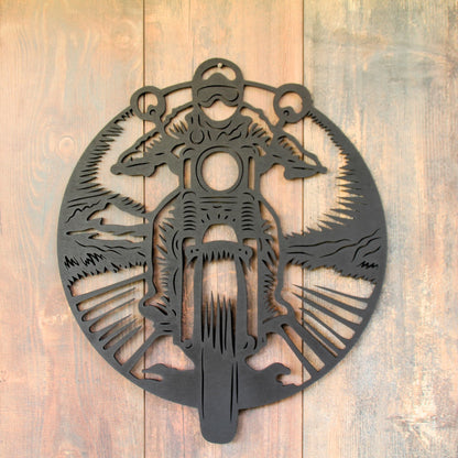 Image d’un biker en mouvement, stylisé en noir sur fond naturel.