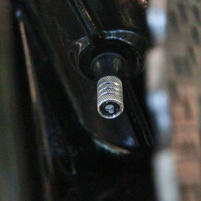 Vue en situation des bouchons de valve moto argentés design crâne. 