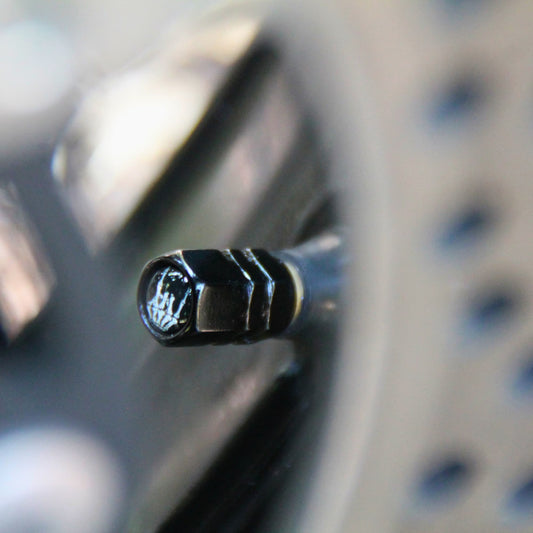 Zoom sur les bouchons de valve moto noirs design main squelette qui fait un signe Rock